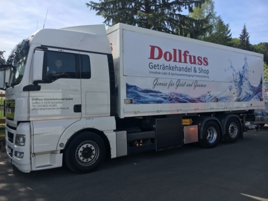 Seitenansicht eines Kühl-LKW mit Dollfuss - Logo und Fahrer in Kabine